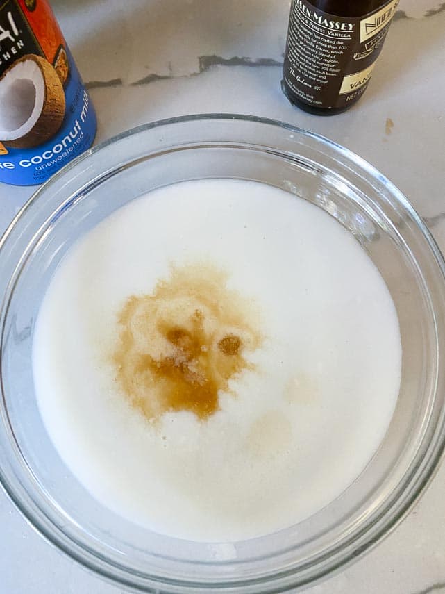 canned lite coconut milk, sugar and vanilla extract in glass bowl