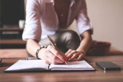 A woman writing in a budget planner